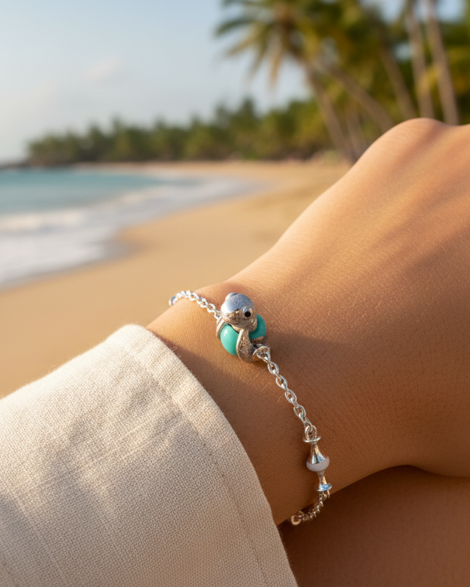 Baby sea turtle charm in polished 950 sterling silver with glossy black enamel eyes, on a glossy Tiffany-blue enamel egg bead — handcrafted jewelry by Priscilla Sayegh