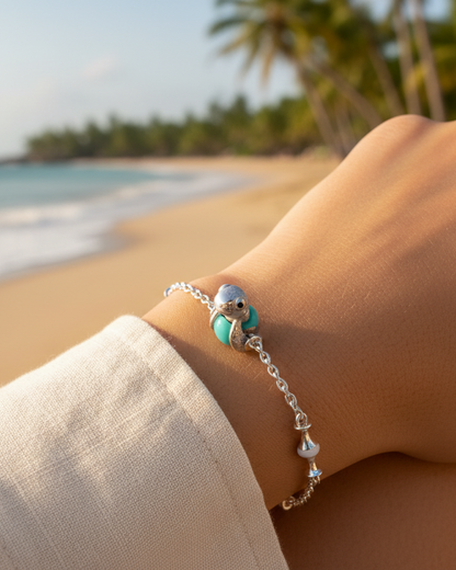 Baby sea turtle charm in polished 950 sterling silver with glossy black enamel eyes, on a glossy Tiffany-blue enamel egg bead — handcrafted jewelry by Priscilla Sayegh